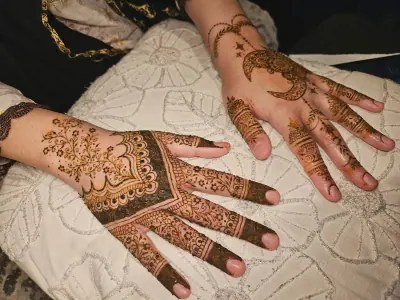 Paired hands with scalloped floral henna and detailed fingertips