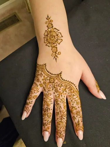 A flowering henna vine with a scalloped border and delicate finger designs