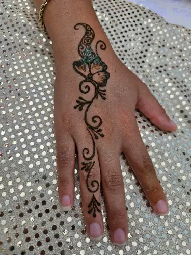 A sweeping paisley henna design with fine curls and a floral detail