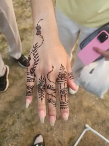 A floral henna vine with filled leaves and detailed finger bands