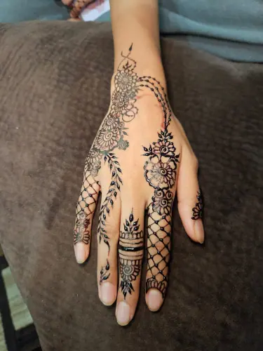A floral henna composition with dense finger lattice and leafy stems