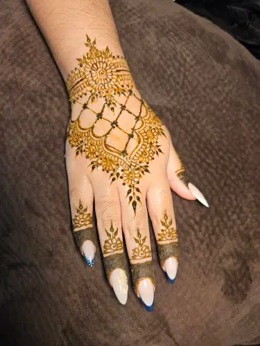 An ornate scalloped henna arch with lattice details and floral fingertips