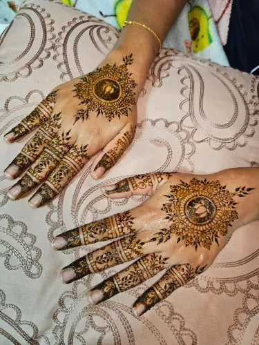 Paired hands with round floral henna medallions and patterned fingers