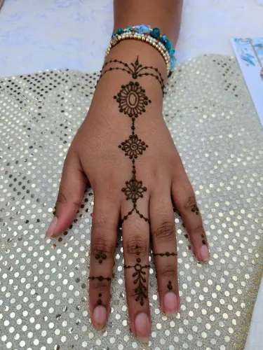 A delicate henna chain connecting two medallions and a fine wrist cuff