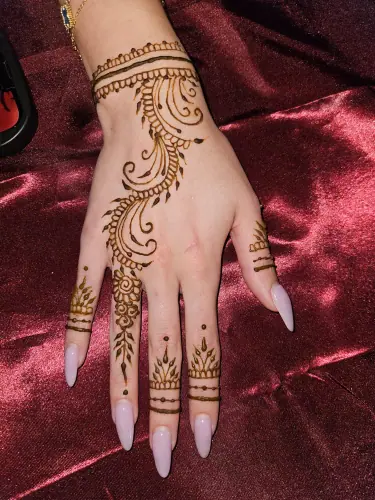 A flowing paisley henna vine with fine wrist and finger bands on burgundy fabric