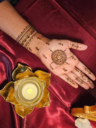 A palm with a circular floral henna medallion, fine dotted chains and patterned fingers
